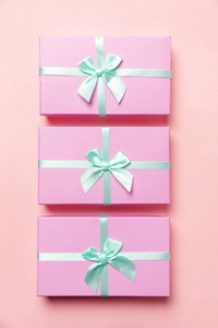 圣诞节新年生日情人节庆典呈现浪漫概念。三个小礼盒包粉红纸隔离在粉彩粉彩的新潮背景上..平躺顶视复印空间