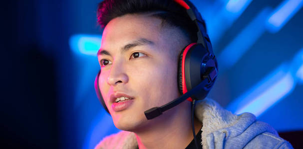 年轻的亚洲帅哥玩网络游戏照片