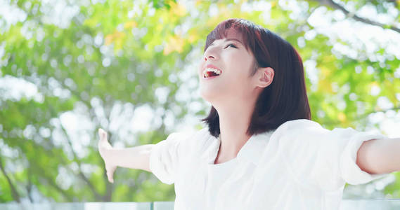 年轻女子感到无忧无虑,在户外深呼吸大自然照片