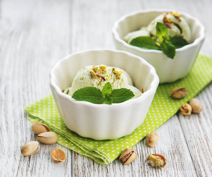 开心果冰淇淋和薄荷与开心果的旧木制背景