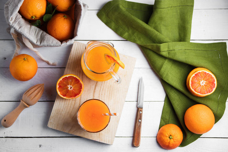 木桌上一杯新鲜的榨汁和血橙子。明亮的夏日心情。顶视图