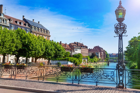 法国斯特拉斯堡阳光明媚的的日子里，用传统的法国建筑描绘了病态河堤的风景