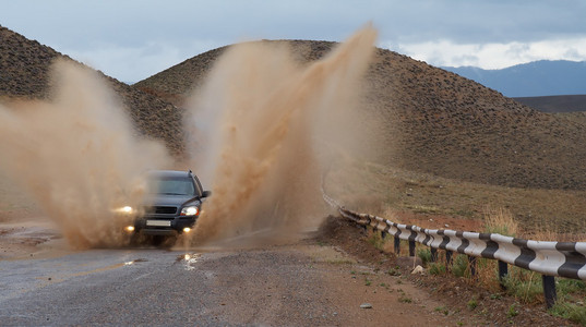 雨后山道路上的 suv。3