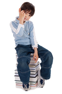年轻的男孩坐在塔的书