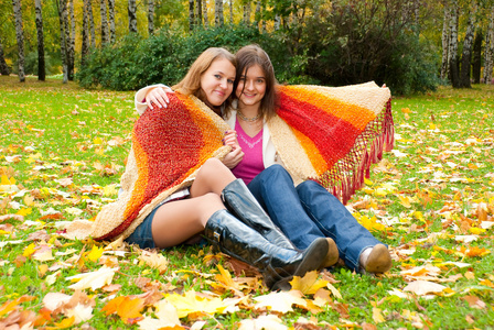 两个女孩坐在秋天公园