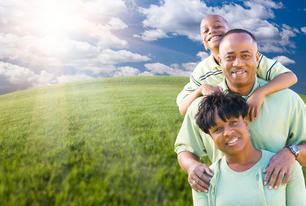 幸福的非洲裔美国家庭在天空的云