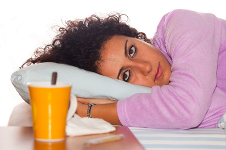 年轻的病女人趴在床照片