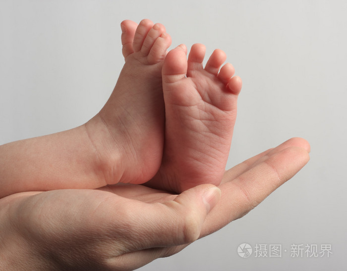 妈妈抱着她孩子的双脚
