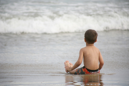 小男孩玩的沙滩和海浪