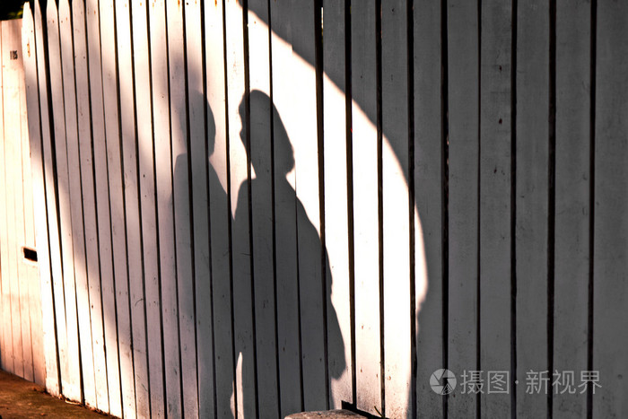 一个男孩与母亲在篱笆墙的影子