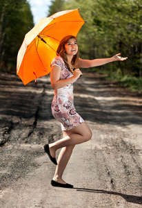 橙色伞的漂亮女孩