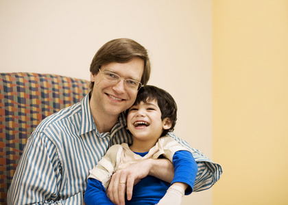 父亲抱着残疾的儿子在医生的办公室