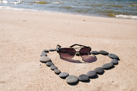 从石头和太阳镜在沙滩上的心