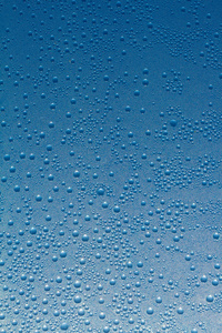 水滴的蓝色玻璃背景上