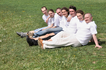 白色 t 短裤的七个朋友在草地上休息一下