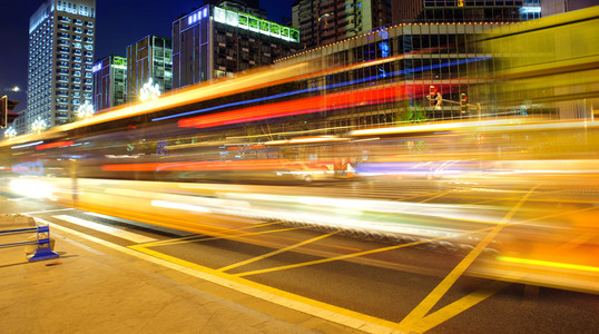 高速度和在市中心夜景模糊的巴士光径