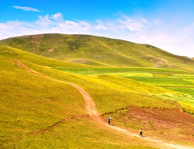 人走在路上在平原和山中的风景照片