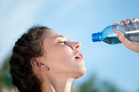 美丽的女人的饮用水。渴