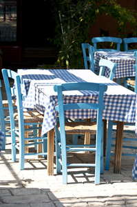 与传统的蓝色桌子和椅子的希腊餐厅