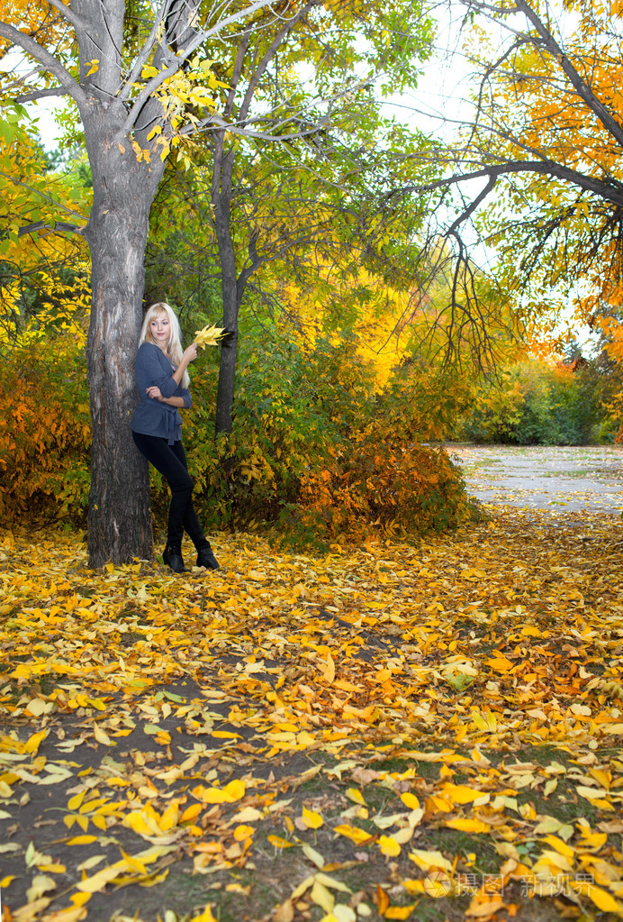 年轻漂亮的女人在秋天公园