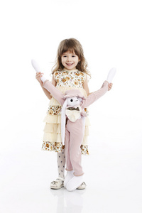 一个微笑的小女孩，玩着一只玩具兔子的肖像