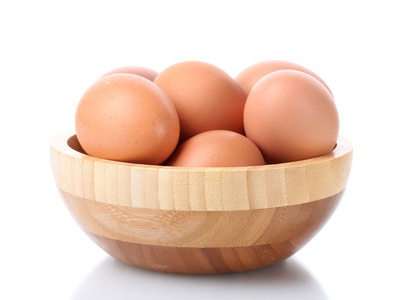棕色鸡蛋在孤立在白色的木碗