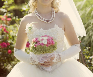 粉红和白色婚礼花束的只鸟手中的玫瑰