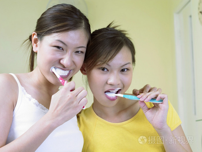 两位女士在一起刷牙
