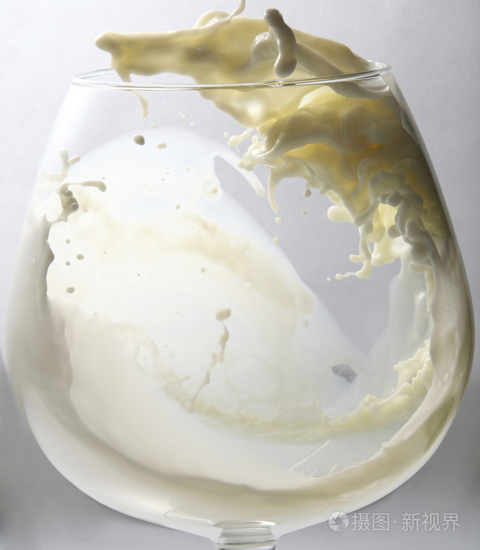 倒牛奶或到杯子的白色液体