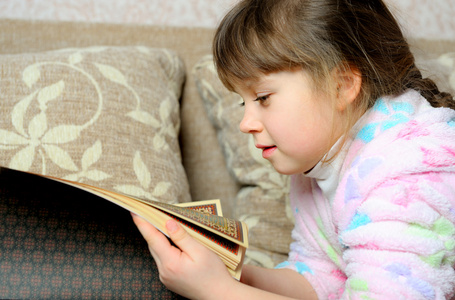 那个小女孩读躺在沙发上的书