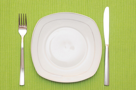 空盘 刀和叉和木桌上的绿色餐巾