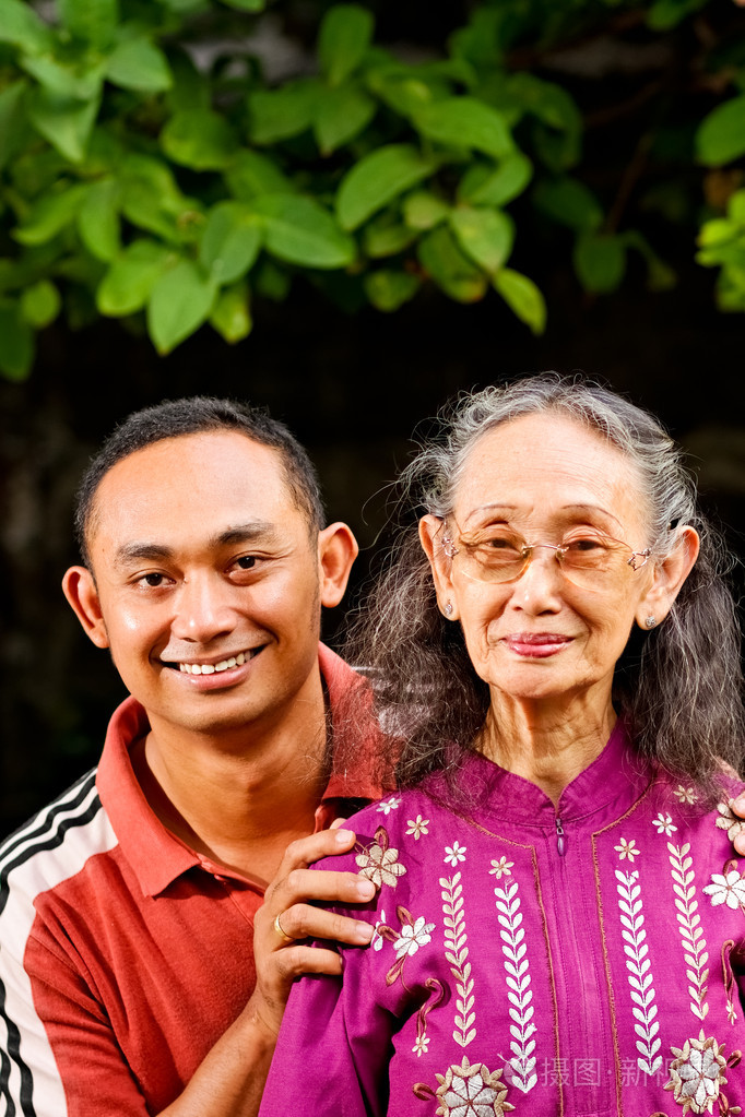 快乐亚洲年轻男子怀抱年迈的母亲