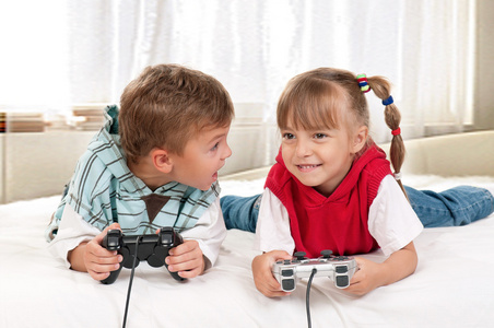 快乐的女孩和男孩在玩视频游戏