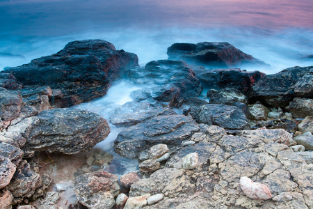 美丽的岩石海海滩日落时