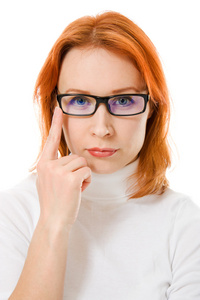 一个美丽的女孩红头发戴着眼镜在白色背景上的思考