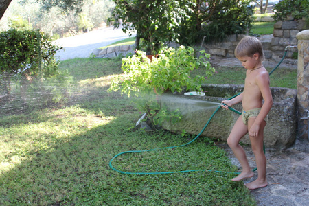 男孩玩花园软管