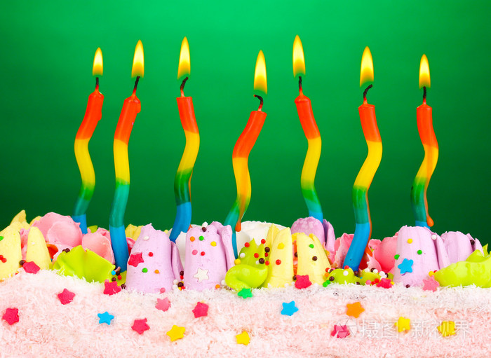 在绿色背景上的蜡烛的生日蛋糕