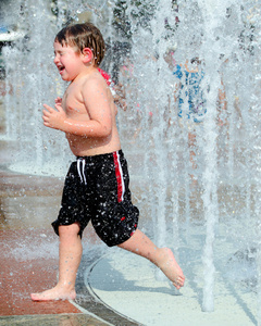 快乐的小男孩或孩子有乐趣上玩在亚特兰大，佐治亚，百年奥林匹克公园喷泉里的水在夏季天气热