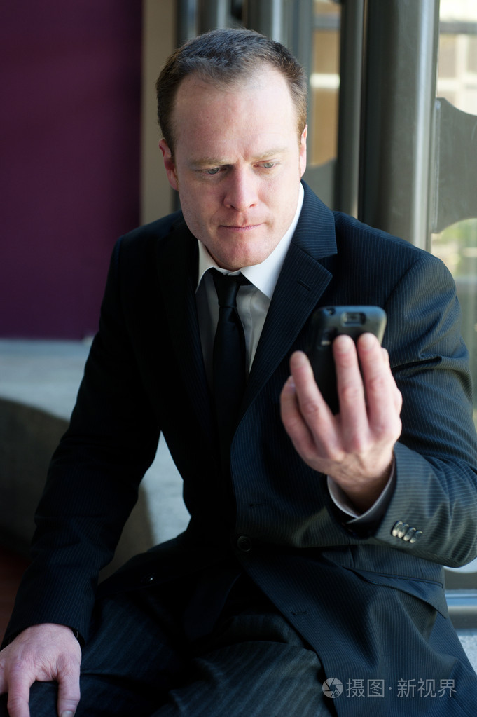 专业商人盯着手机