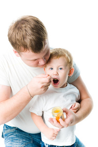 男子喂养婴儿苹果酱用勺子，白棉背景上