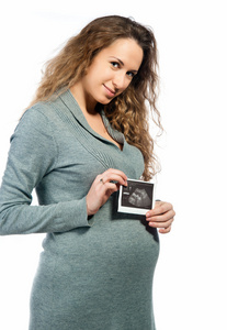 怀孕的女人拿着超声张照片