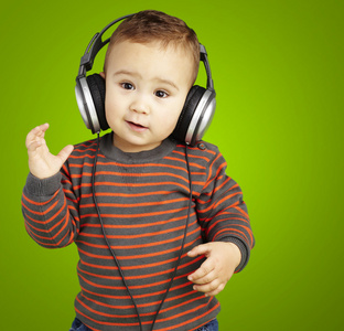 可爱的孩子，戴着耳机听音乐反对的肖像