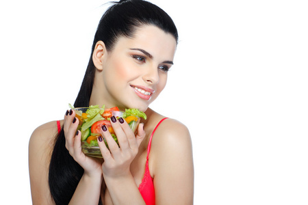 一个年轻漂亮的女人吃蔬菜沙拉孤立在白色背景上的肖像