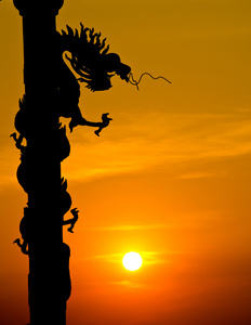 中国风格龙雕像剪影与日落