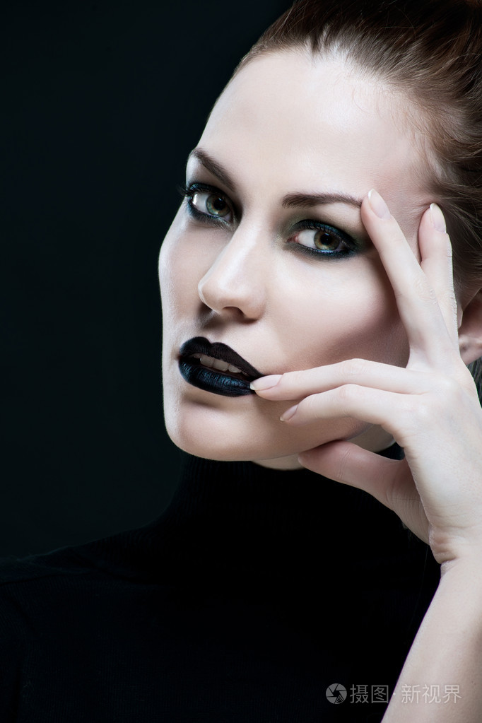一个美丽的女人用黑色的嘴唇的画像黑色背景上