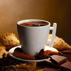 喝杯热巧克力 肉桂棒 坚果和巧克力棕色背景上的木桌上
