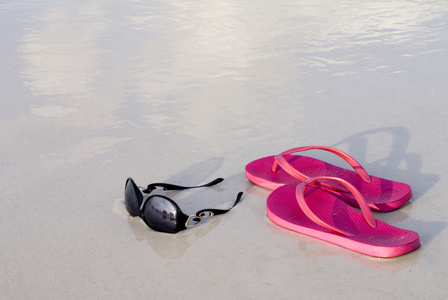 拖鞋和海滩上的太阳镜