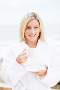 年轻女子穿浴袍喝咖啡图片