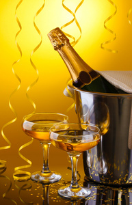 与冰和眼镜的香槟，在黄色背景上的存储桶中的香槟瓶
