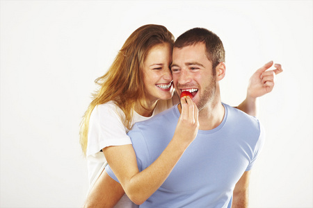 快乐的年轻夫妻一起吃草莓